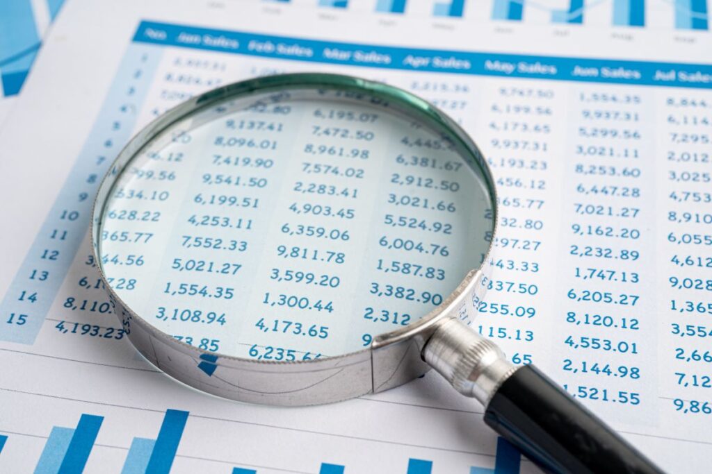 a small business bookkeeper consolidating payroll and invoices into a spreadsheet