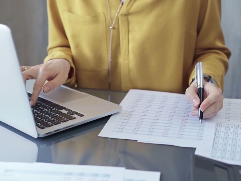 Accountant reviewing financial records and documents during office work.
